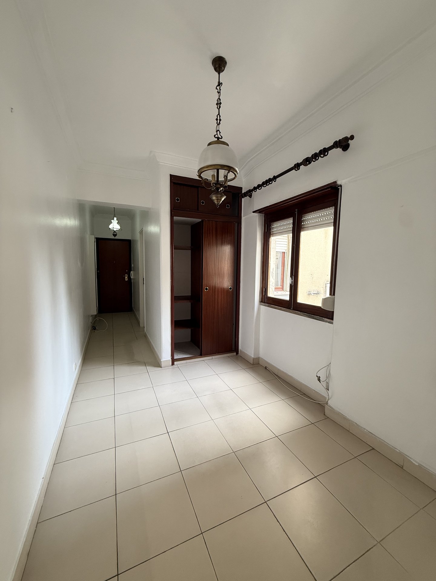 Quarto com roupéiro antigo virado para o hall
