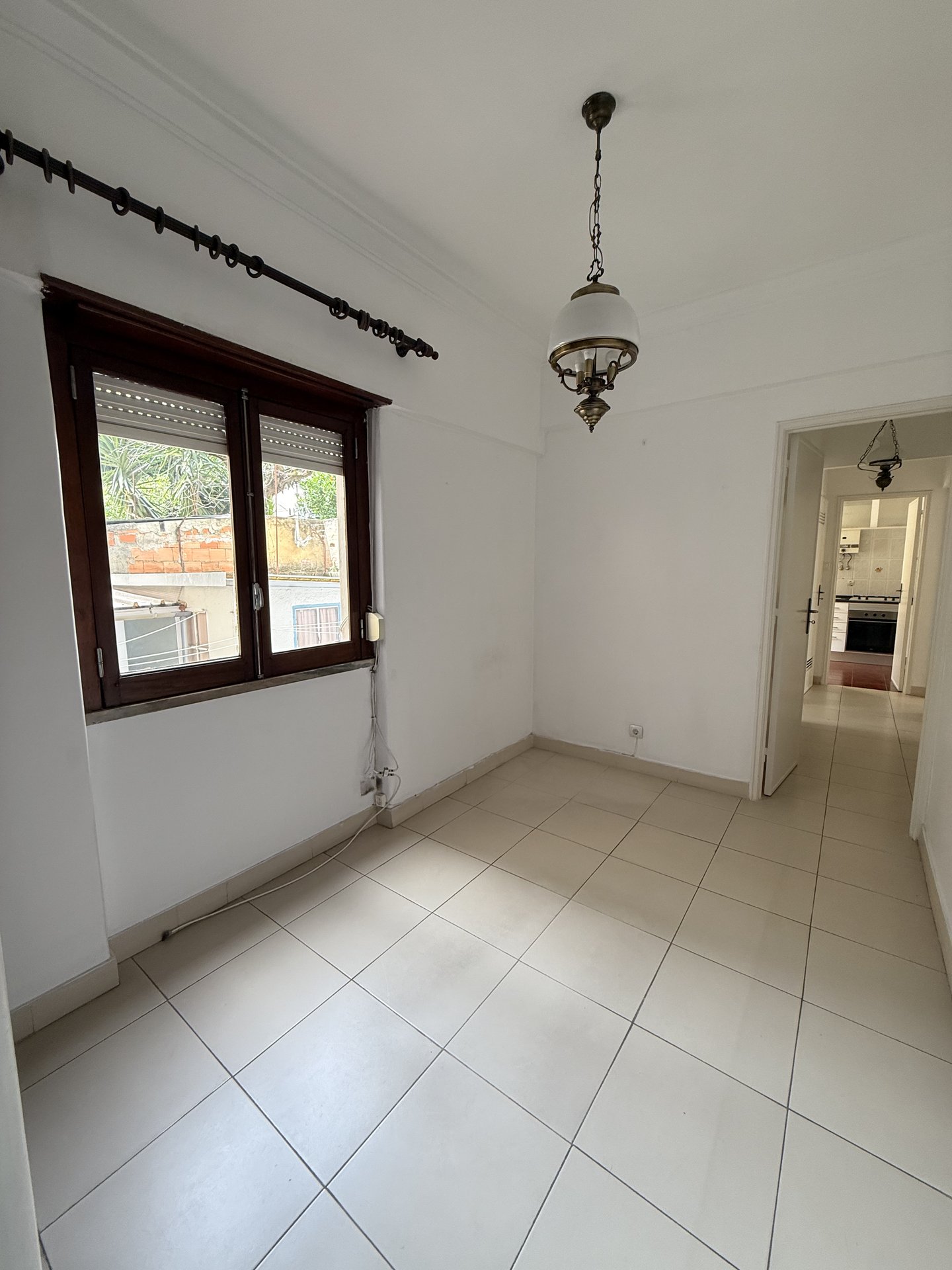 Divisão com pavimento cerâmico antigo e vista para a cozinha